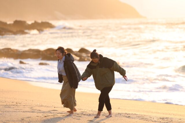 夕暮れの屋久島でビーチ散歩を楽しむ人々
