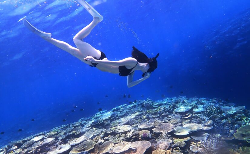 屋久島の透明度の高い海でシュノーケリングを楽しむ女性。