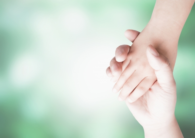 手をつなぐ二人の手、温かい感触を伝えるシンプルな画像