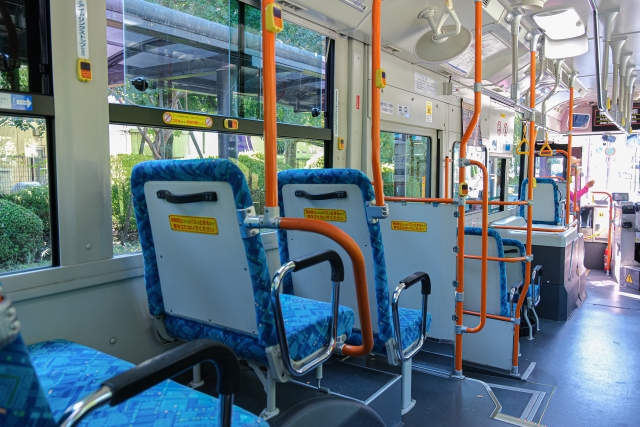 屋久島の路線バス車内。青いシートとオレンジのつり革