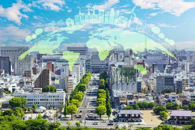 街並みを背景に、環境保護を象徴する地球を表現したイラストが重ねられた画像