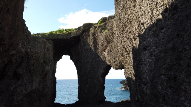 海に向かって開いた自然の岩のアーチ、青空と海の美しい風景が見える