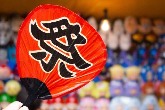 お祭りの屋台で売られる赤い団扇