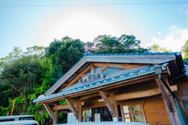 尾之間温泉の外観と青空