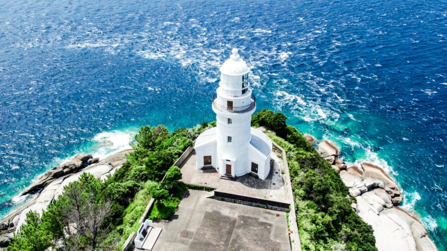 屋久島灯台を上空から見た空撮写真、青い海と永田岬の絶景