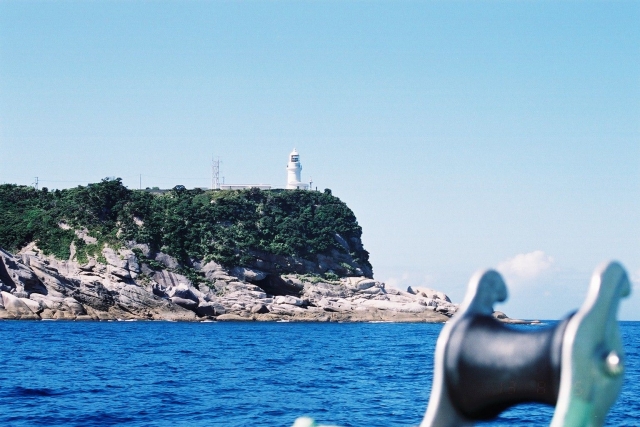 海上の船から見た屋久島灯台と永田岬の風景